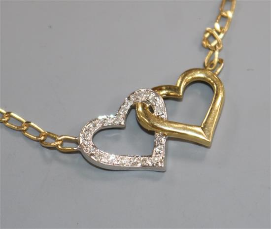 An 18ct gold and diamond set two colour twin hearts pendant necklace, approx. 37cm.